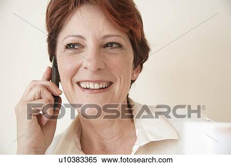 Stock Photography - Smiling woman talking on cell phone. Fotosearch