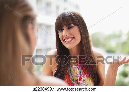 Smiling woman talking to friend View Large Photo Image Stock Photo - Smiling woman talking to friend. Fotosearch