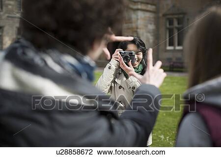 Stock Image - Student taking picture of friends. Fotosearch