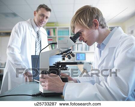 Stock Photo - Student using microscope in classroom. Fotosearch