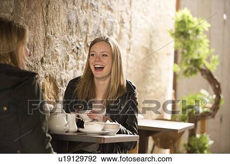 Stock Image - Students having tea in cafe. Fotosearch