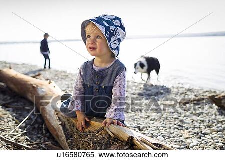 Toddler girl climbing on log by creek View Large Photo Image Stock Photography - Toddler girl climbing on log by creek. Fotosearch