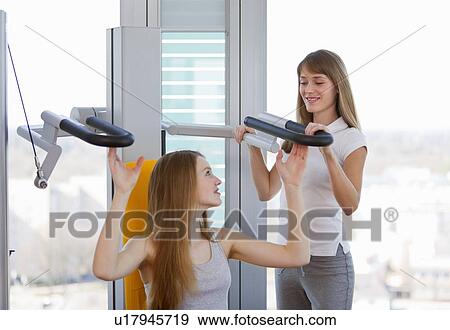 Trainer working with girl in gym View Large Photo Image Stock Photo - Trainer working with girl in gym. Fotosearch