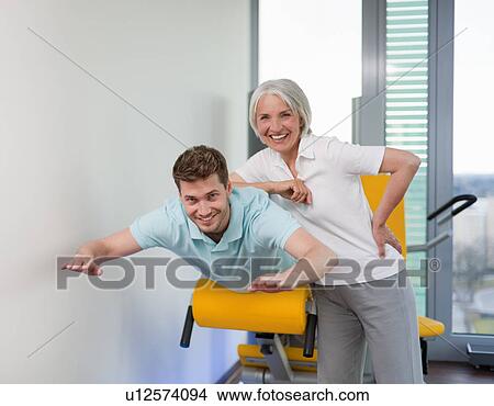 Trainer working with man in gym View Large Photo Image Picture - Trainer working with man in gym. Fotosearch