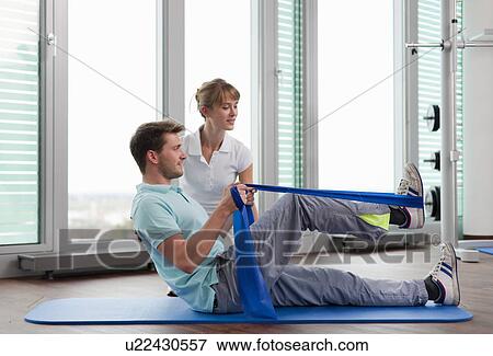 Trainer working with man in gym View Large Photo Image Stock Photo - Trainer working with man in gym. Fotosearch