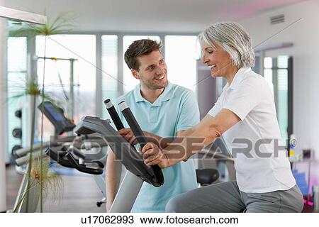Trainer working with woman in gym View Large Photo Image Stock Image - Trainer working with woman in gym. Fotosearch