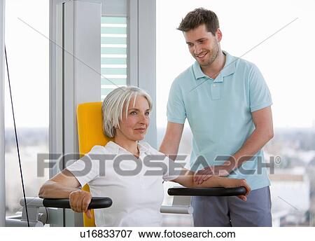 Trainer working with woman in gym View Large Photo Image Stock Photo - Trainer working with woman in gym. Fotosearch