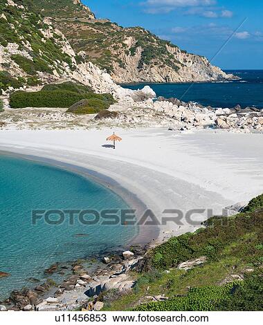 Stock Image - Umbrella on deserted tropical beach. Fotosearch