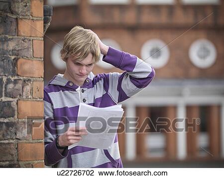 Upset student reading grades at school View Large Photo Image Stock Image - Upset student reading grades at school. Fotosearch