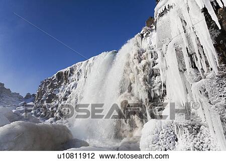 Stock Image - Waterfall and icicles on cliffs. Fotosearch