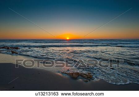 Waves crashing on sandy beach at sunrise View Large Photo Image Stock Image - Waves crashing on sandy beach at sunrise. Fotosearch