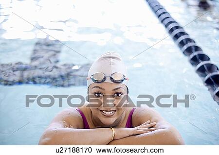 Stock Image - Woman at edge of swimming pool. Fotosearch