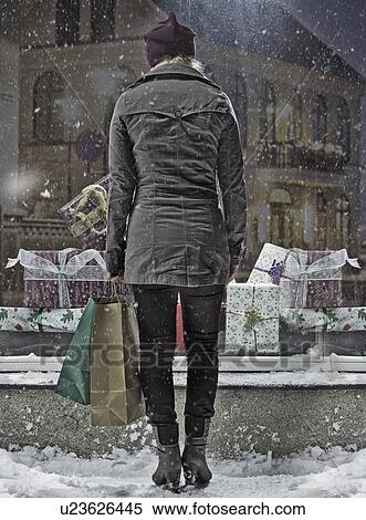 Stock Photography - Woman carrying shopping bags in snow. Fotosearch