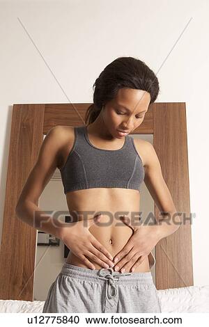 Woman examining her stomach View Large Photo Image Stock Image - Woman examining her stomach. Fotosearch