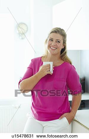 Woman having cup of coffee in kitchen View Large Photo Image Stock Image - Woman having cup of coffee in kitchen. Fotosearch