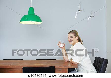 Woman having glass of water at table View Large Photo Image Stock Image - Woman having glass of water at table. Fotosearch