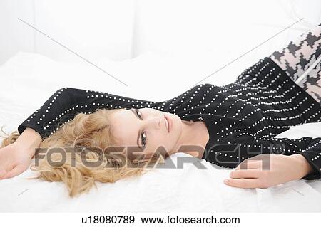 Woman laying on bed View Large Photo Image Stock Photo - Woman laying on bed. Fotosearch