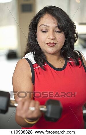 Woman lifting weights in gym View Large Photo Image Stock Photo - Woman lifting weights in gym. Fotosearch
