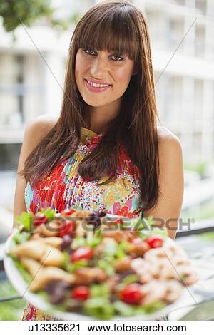Woman offering plate of salad outdoors View Large Photo Image Stock Image - Woman offering plate of salad outdoors. Fotosearch