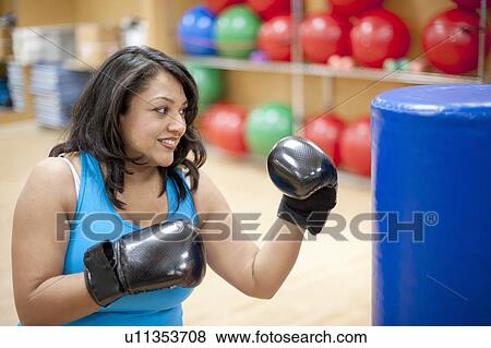 Woman punching bag in gym View Large Photo Image Stock Photo - Woman punching bag in gym. Fotosearch