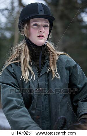 Stock Image - Woman riding horse outdoors. Fotosearch
