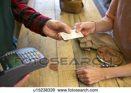 Stock Photo - Woman shopping with credit card in store. Fotosearch