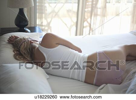 Stock Image - Woman sleeping in bed. Fotosearch