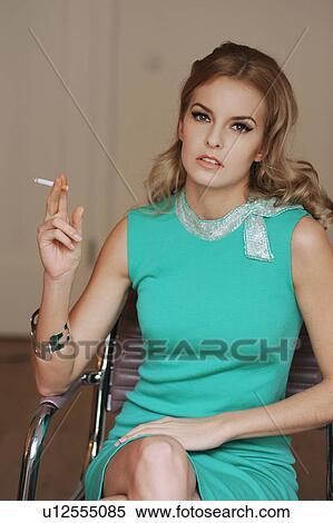 Stock Photography - Woman smoking cigarette in armchair. Fotosearch