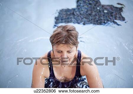 Woman splashing in swimming pool View Large Photo Image Stock Photograph - Woman splashing in swimming pool. Fotosearch