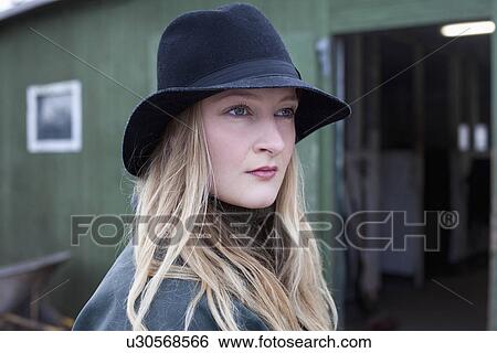 Woman standing outside stable View Large Photo Image Stock Photograph - Woman standing outside stable. Fotosearch