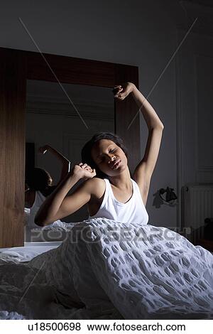 Woman stretching in bed View Large Photo Image Stock Photo - Woman stretching in bed. Fotosearch