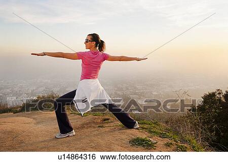 Woman stretching on hilltop View Large Photo Image Stock Photograph - Woman stretching on hilltop. Fotosearch