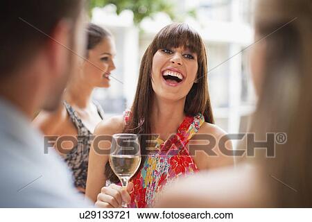 Stock Image - Woman talking in group at party. Fotosearch