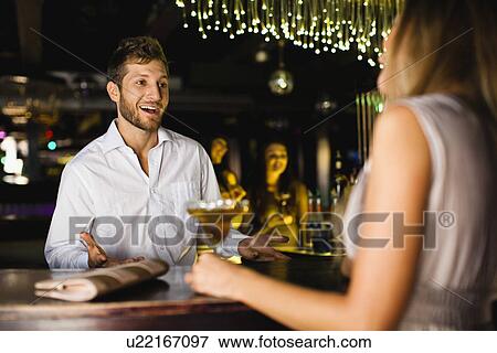 Woman talking to bartender at bar View Large Photo Image Stock Photo - Woman talking to bartender at bar. Fotosearch