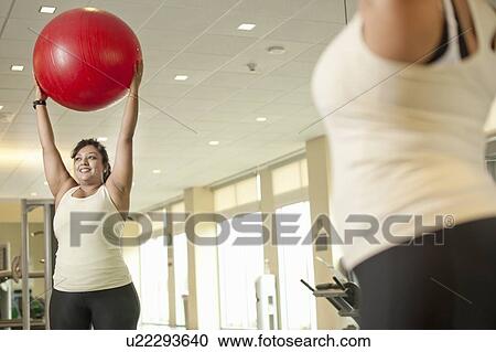 Woman using exercise ball in gym View Large Photo Image Stock Image - Woman using exercise ball in gym. Fotosearch