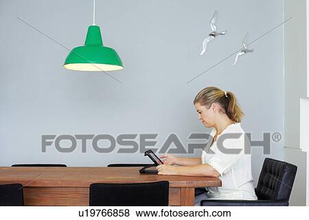 Woman using tablet computer at table View Large Photo Image Stock Photo - Woman using tablet computer at table. Fotosearch