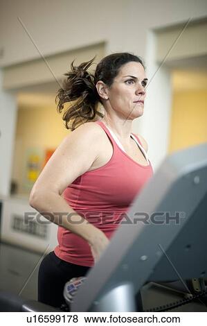 Woman using treadmill in gym View Large Photo Image Stock Photo - Woman using treadmill in gym. Fotosearch