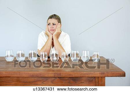 Woman with glasses of water on table View Large Photo Image Stock Image - Woman with glasses of water on table. Fotosearch
