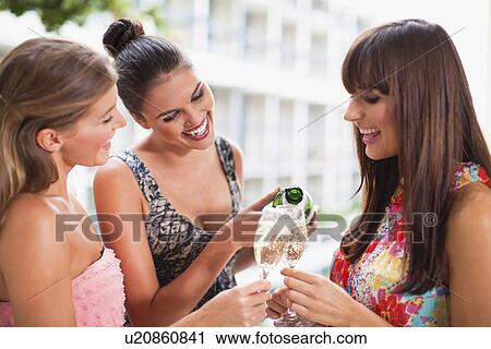 Stock Image - Women drinking champagne together. Fotosearch