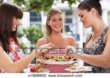 Stock Photography - Women eating hors doeurves together. Fotosearch