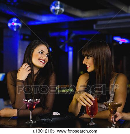 Women having drinks together at bar View Large Photo Image Stock Photography - Women having drinks together at bar. Fotosearch