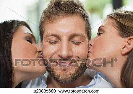 Women kissing smiling mans cheeks View Large Photo Image Stock Image - Women kissing smiling mans cheeks. Fotosearch
