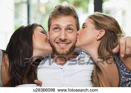 Women kissing smiling mans cheeks View Large Photo Image Stock Photo - Women kissing smiling mans cheeks. Fotosearch
