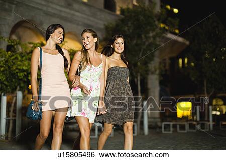 Women walking on city street at night View Large Photo Image Stock Photograph - Women walking on city street at night. Fotosearch