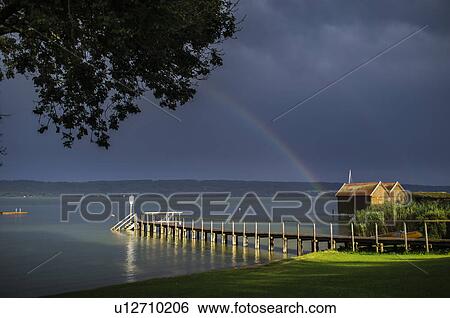 Wooden pier stretching into still water View Large Photo Image Stock Photograph - Wooden pier stretching into still water. Fotosearch