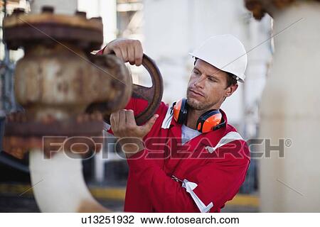 Worker adjusting gauge at chemical plant View Large Photo Image Stock Image - Worker adjusting gauge at chemical plant. Fotosearch