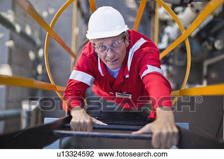 Worker climbing ladder at oil refinery View Large Photo Image Stock Image - Worker climbing ladder at oil refinery. Fotosearch