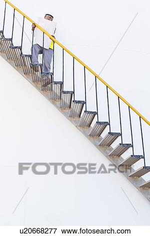 Worker climbing steps at chemical plant View Large Photo Image Stock Photo - Worker climbing steps at chemical plant. Fotosearch