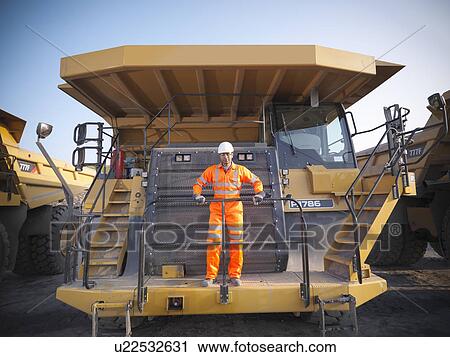 Stock Image - Worker on equipment in coal mine. Fotosearch