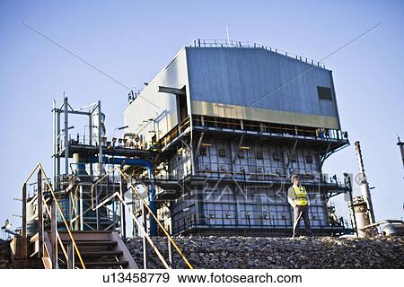 Worker standing at chemical plant View Large Photo Image Stock Photo - Worker standing at chemical plant. Fotosearch